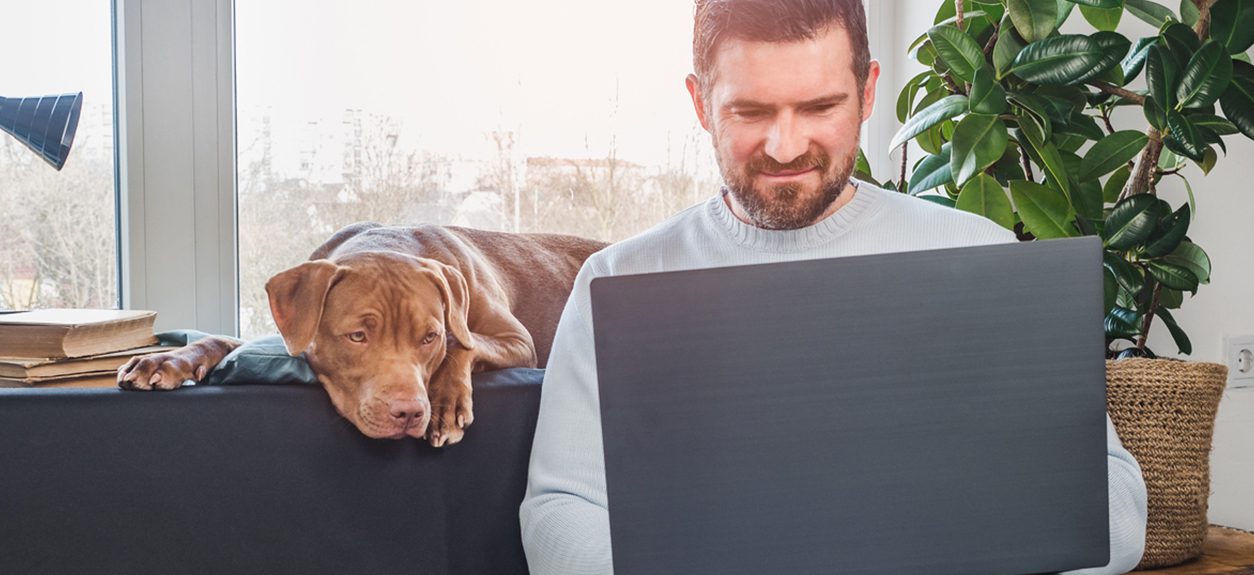 man-on-computer-with-dog