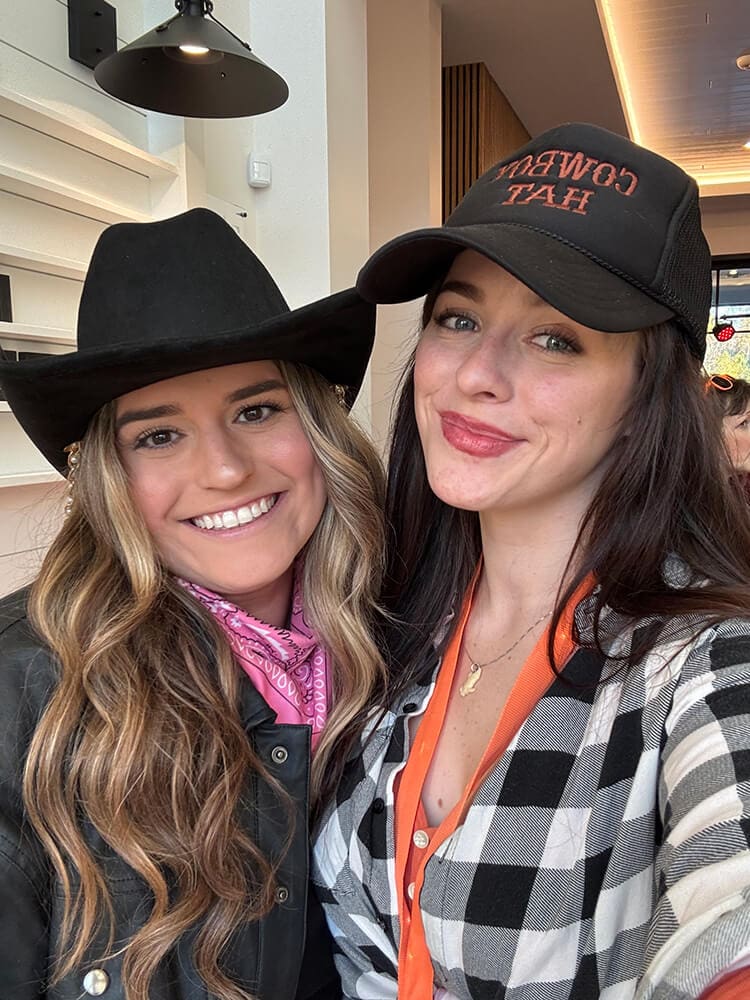 two women smiling for camera in hats