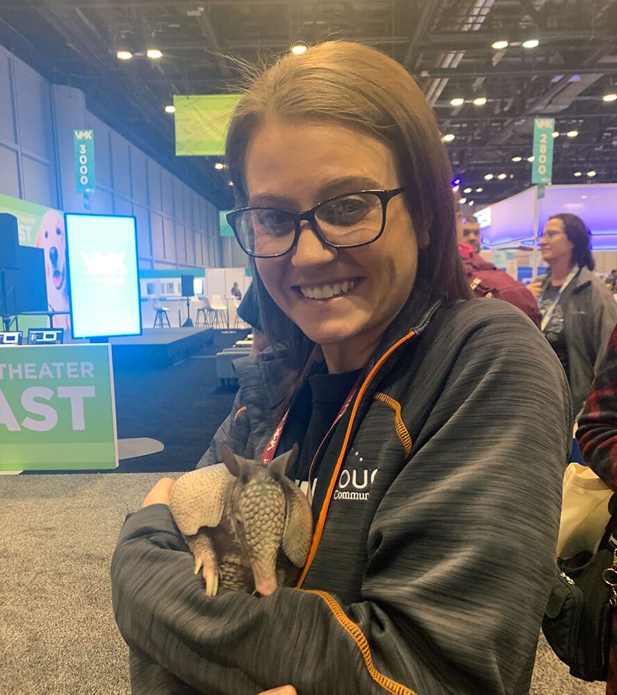 woman holding small armadillo at tradeshow