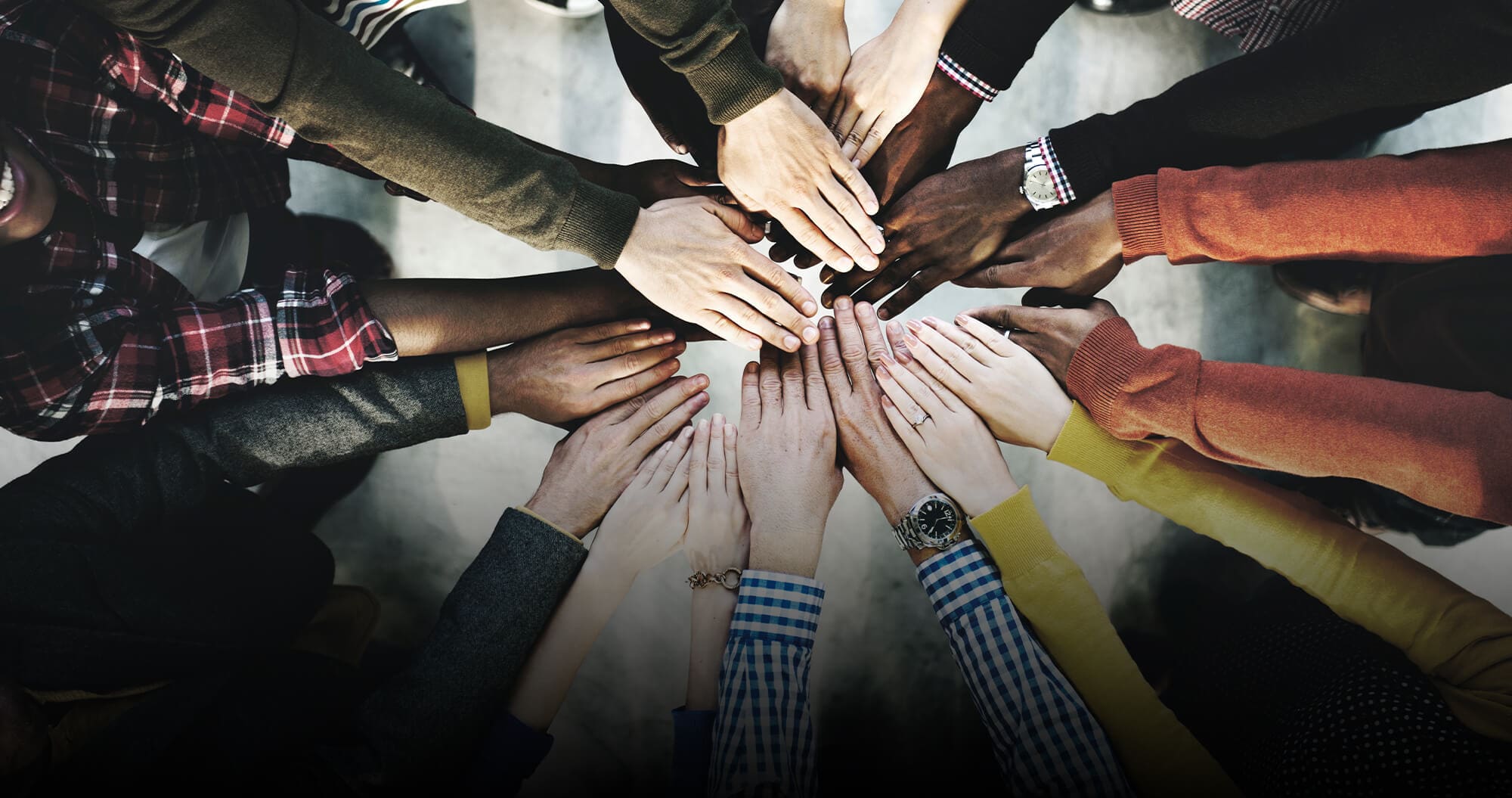 a group of people with hands in the center, from above