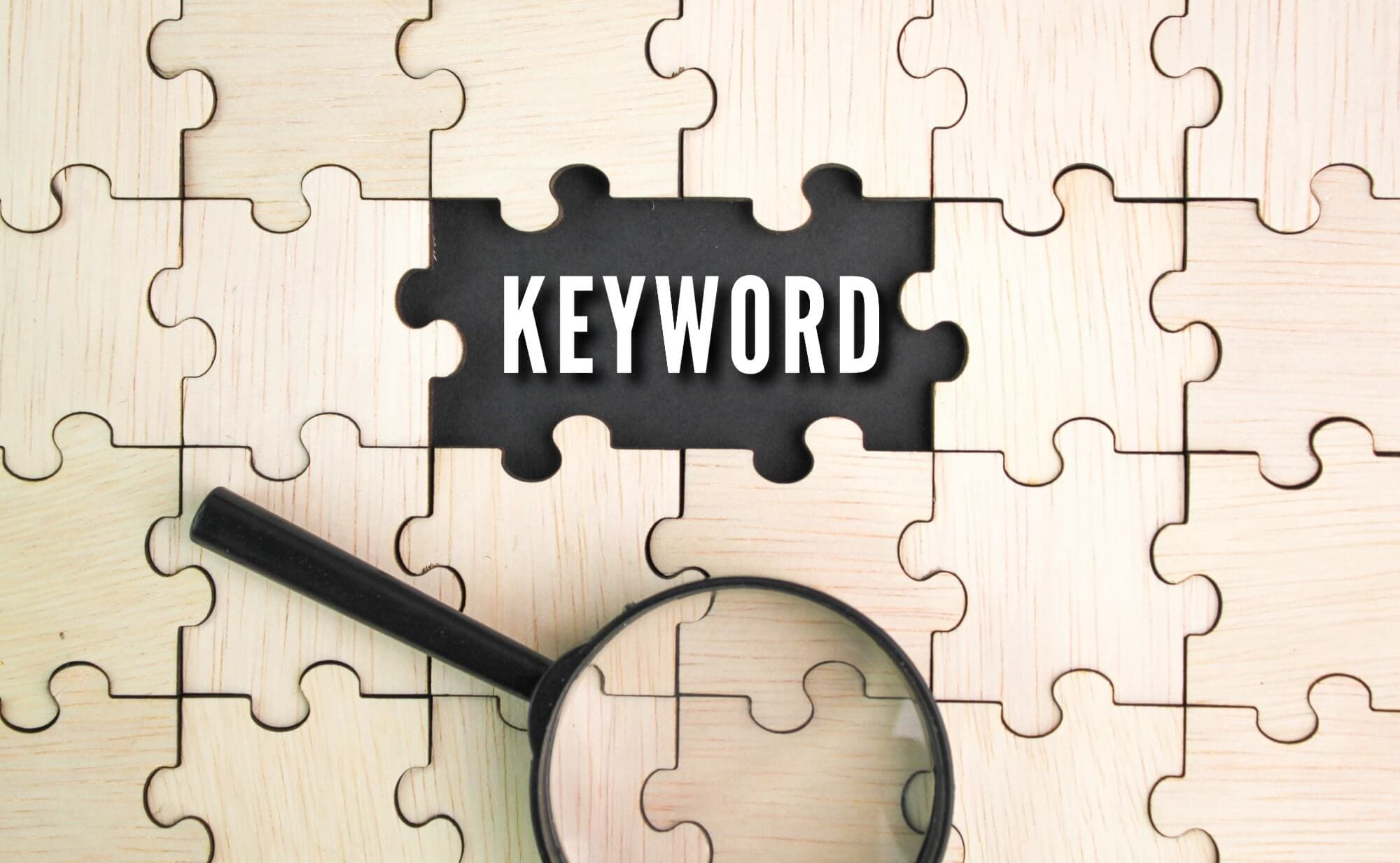 puzzle with blank tiles and "keyword" in the middle with magnifying glass